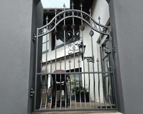 schmiedetor-koenigsbrunn-ansicht-seitlich Schmiedetor mit Zierspitzen und Bogenform – Gesamtansicht aus seitlicher Perspektive in Königsbrunn