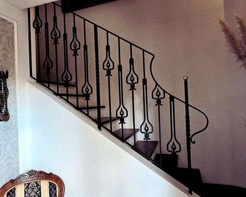 gelaender-detail-ornament-schwarz-messing-augsburg Elegantes Treppengeländer aus Stahl mit traditionellen Schmiedeornamenten und Messingabschlüssen