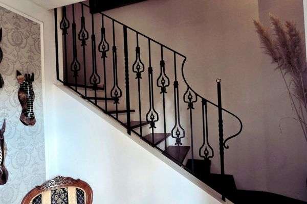 gelaender-detail-ornament-schwarz-messing-augsburg Elegantes Treppengeländer aus Stahl mit traditionellen Schmiedeornamenten und Messingabschlüssen